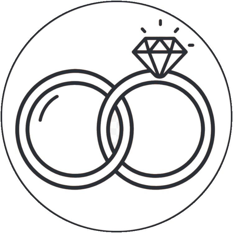 Zwei ineinander greifende Ringe, einer schlicht und einer mit einem großen Diamanten auf der Spitze, schwarz umrandet in einer kreisförmigen Umrandung - perfekt, um die Liebe in der Krahl Bäckerei & Konditorei zu feiern.